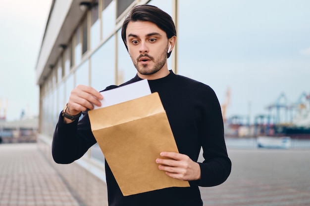 Person excitedly opening an envelope with a response