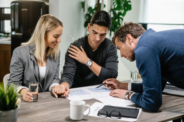 Couple reviewing housing plans with a real estate agent