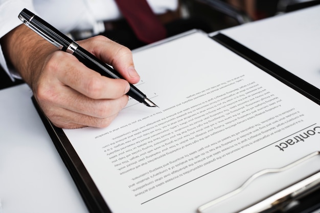 Hand signing a business contract and pre-approval letter