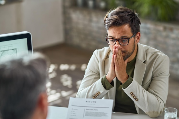 Young man looking uncertain during a financial interview